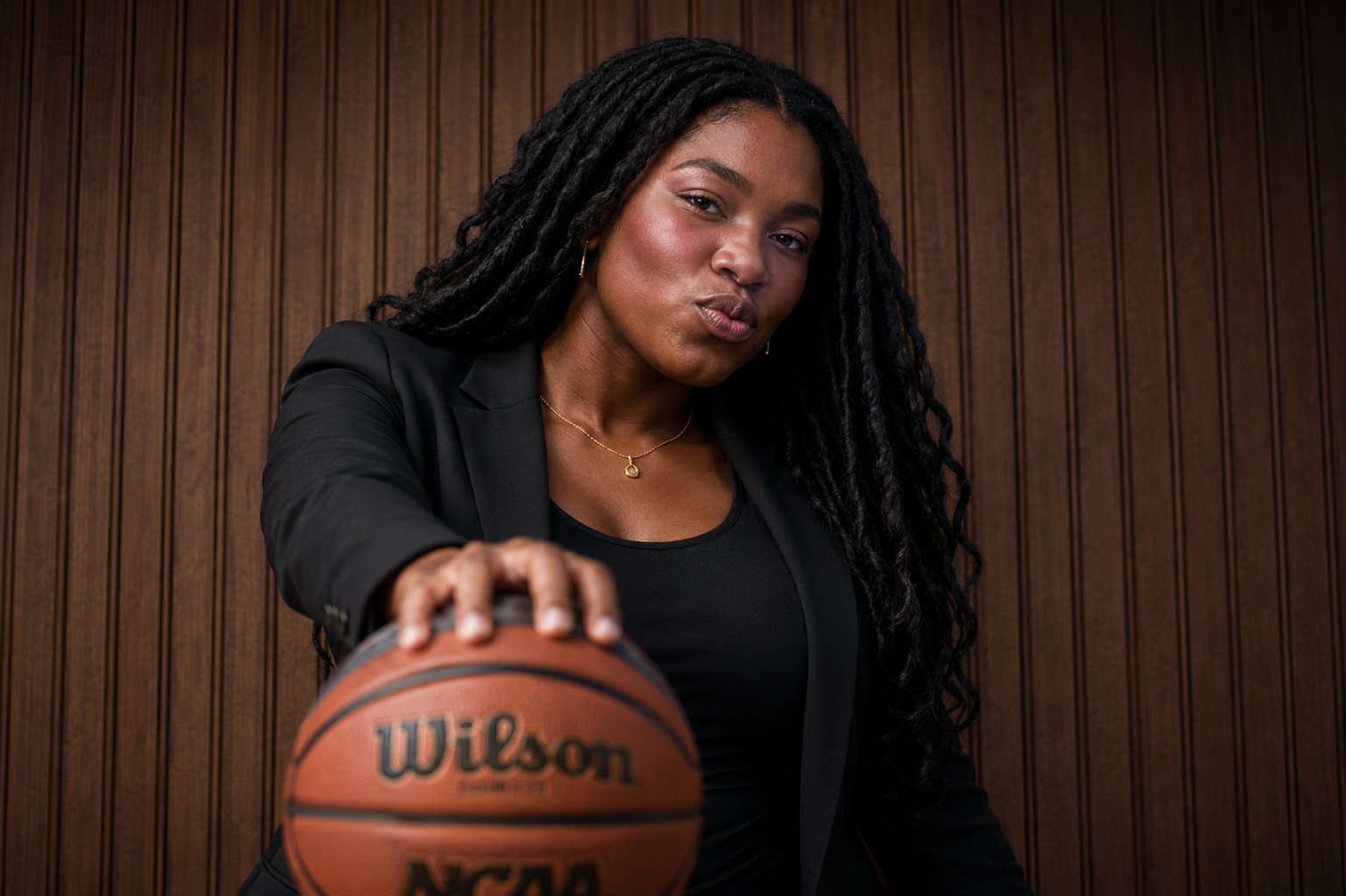A confident Evolve team member holding a basketball in the office